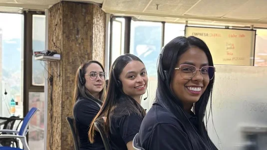 Equipo del call center de Elite sonriendo en sus puestos de trabajo
