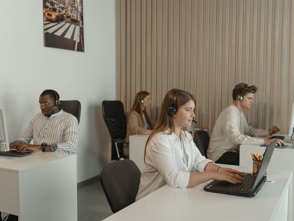 Asesores con diadema atendiendo en sus puestos de trabajo del call center